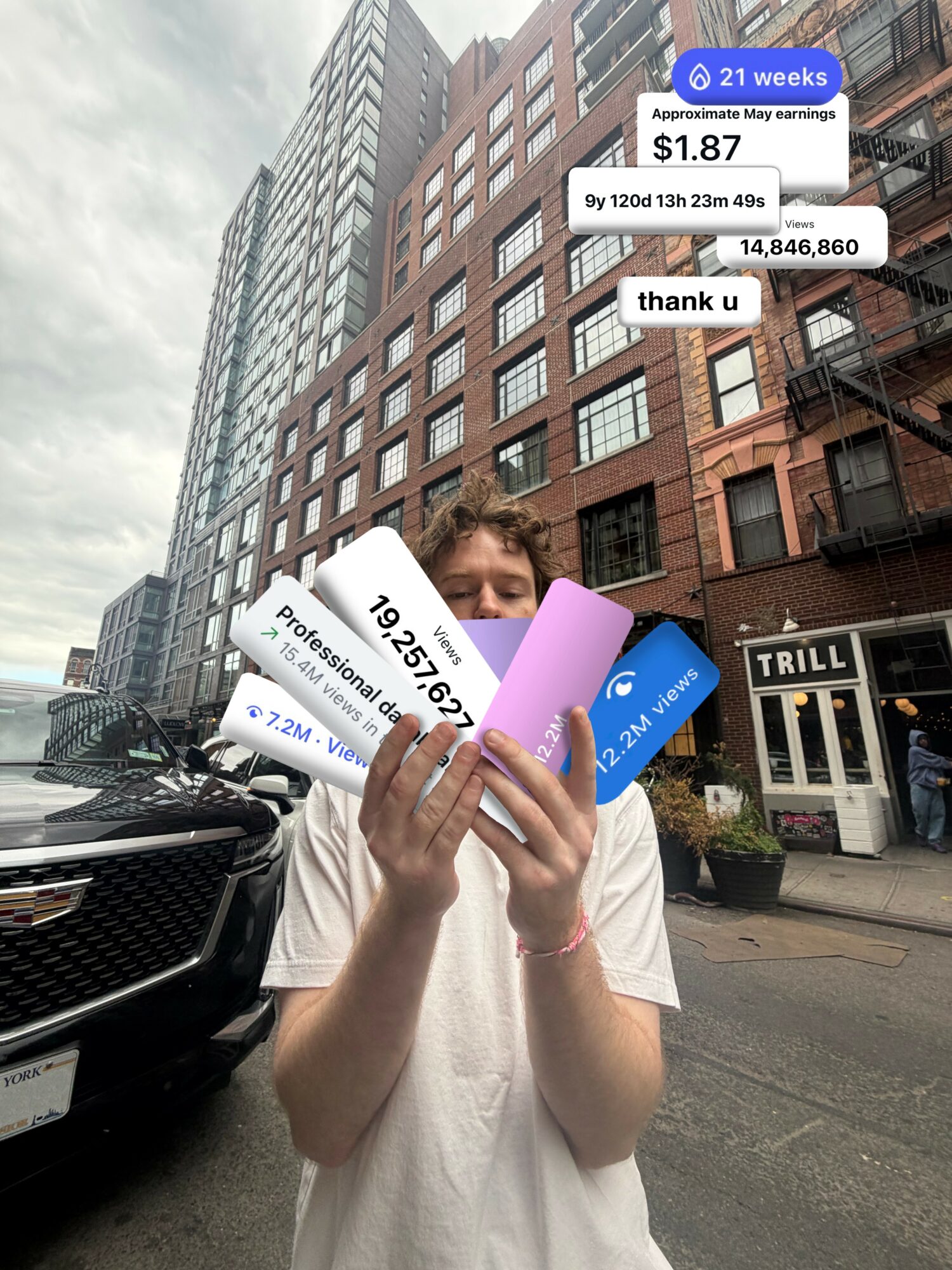 Person holding a smartphone and financial signs on a city street with tall buildings in the background.