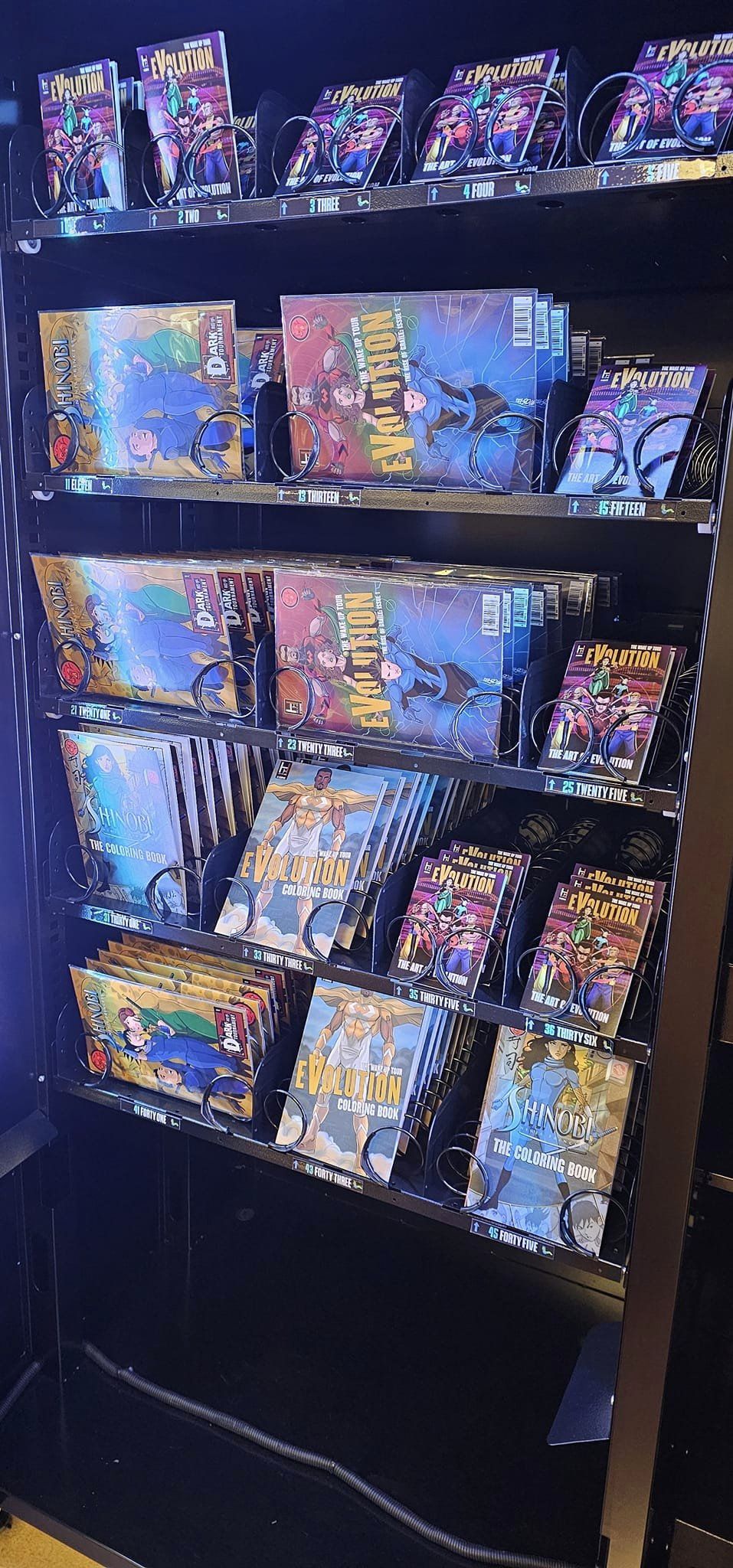 Black shelf with multiple colorful comic books and graphic novels arranged in rows.