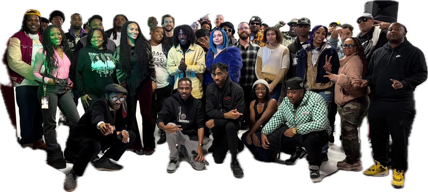 Group of diverse people standing and kneeling together, some wearing masks and casual clothing, in a studio setting.